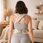 maman brune dans son salon, cocooning beige, essaye son porte bébé. vue de dos,  ceinture ajustable
