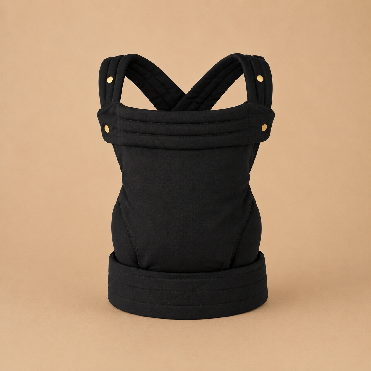 Porte-bébé kangourou physiologique et  noir présenté, vue de face, bretelles rembourrées, sangle ajustable sur fond beige