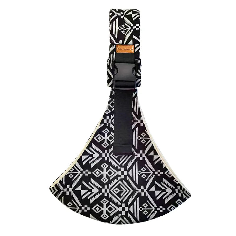 Porte-bébé style sling, vue de face, bretelle rembourrée, fermeture sécurisée. Motifs aztek coloris noir.
