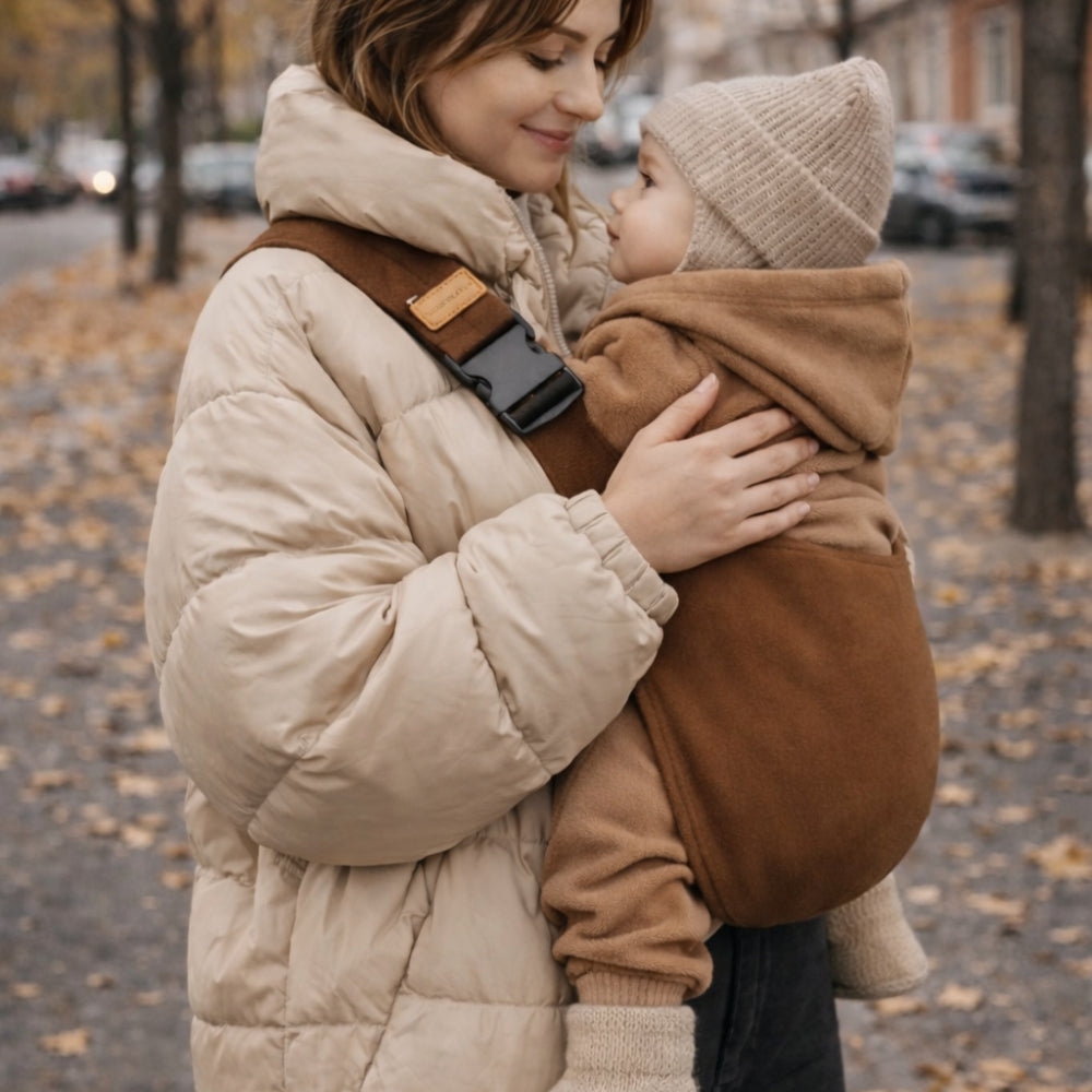 porte-bébé sling portage hanche, vue sur le coté, le bébé est apaise car tenu par sa maman. Bandoulière maintient l'enfant