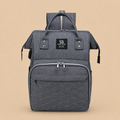 Sac à dos à langer gris sur un fond beige nuancier en vue de face