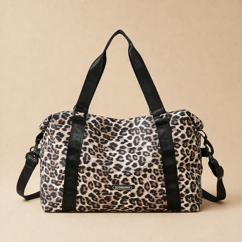 Sac à langer bébé coloris léopard sur fond  beige, vue de face. Pratique, confortable et stylé pour le quotidien. Bandoulière et motifs visibles
