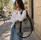 Maman brune qui se balade avec son sac à langer léopard. Elle a dans son sac l'essentiel de bébé pour la journée