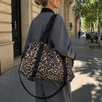 Maman blonde qui se balade avec son sac à langer léopard. Elle a dans son sac l'essentiel de bébé pour la journée en ville
