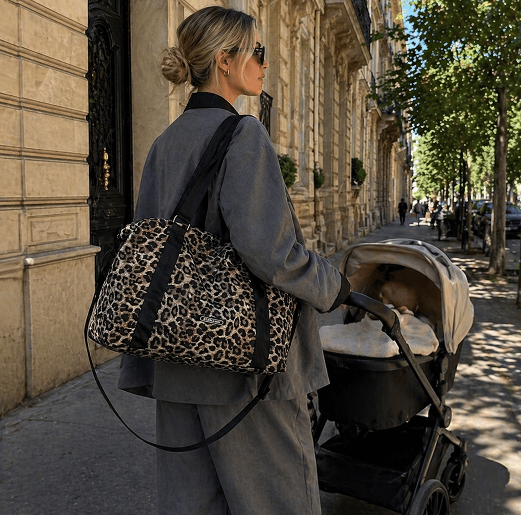 Maman blonde qui se balade avec sa poussette et son sac à langer léopard. Elle a dans son sac l'essentiel de bébé pour la journée