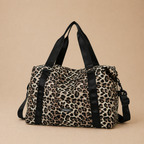 Sac à langer bébé coloris léopard sur fond  beige, vue de face. Pratique, confortable et stylé pour le quotidien