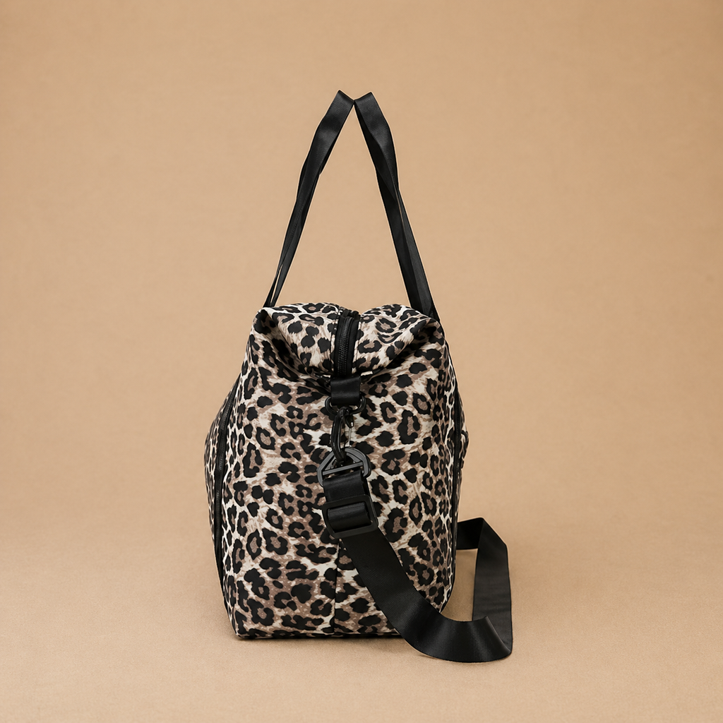Sac à langer bébé coloris léopard sur fond  beige, vue de côté. Pratique, confortable et stylé pour le quotidien