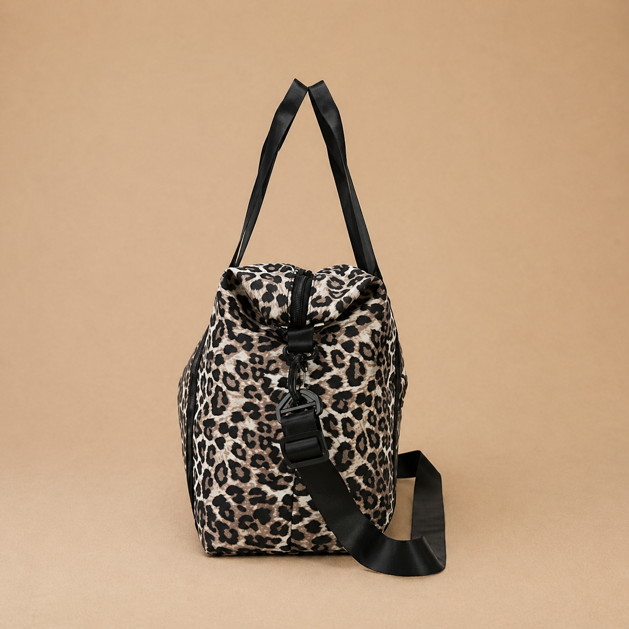 Sac à langer bébé coloris léopard sur fond  beige, vue de côté. Pratique, confortable et stylé pour le quotidien
