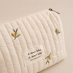 Trousse de rangement beige motif olive, parfait pour l'essentiel de votre bébé. Avec un arrière plan beige nuancier en vue de côté sur les motifs et le logo