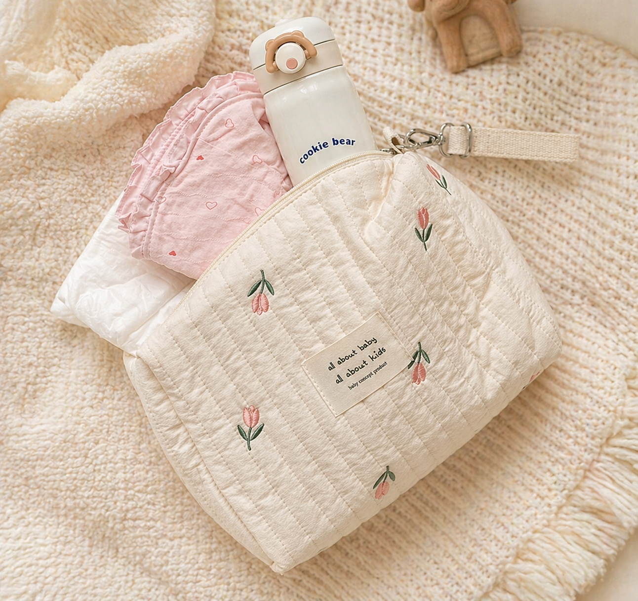 Trousse de rangement beige motif olive, parfait pour l'essentiel de votre bébé. Avec un arrière plan beige cocooning et une vue sur les indispensables bébé